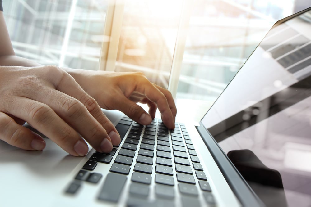 Double exposure of business person's hands working on blank screen laptop computer on wooden desk as concept